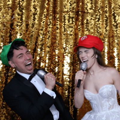 Bride and groom having fun in a photo booth with a gold sequin backdrop at a Chicago wedding reception