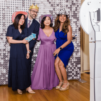 Wedding guests posing at a photo booth with props and a silver sequin backdrop at a Chicago wedding reception